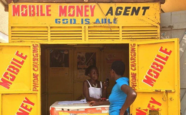 Hình ảnh Mobile Money Agent" thực hiện nhiệm vụ đổi tiền từ tài khoản di động sang tiền mặt cho người dân Châu Phi hiện nay 